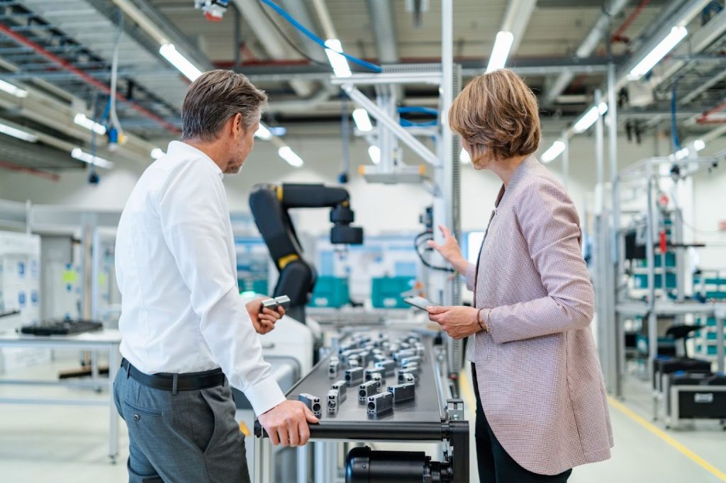 Co workers discussing smart factory machine operations